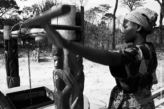 030_CZmA.8800BW-African-Village-Woman-&-Carved-Water-Well-NW-Zambia